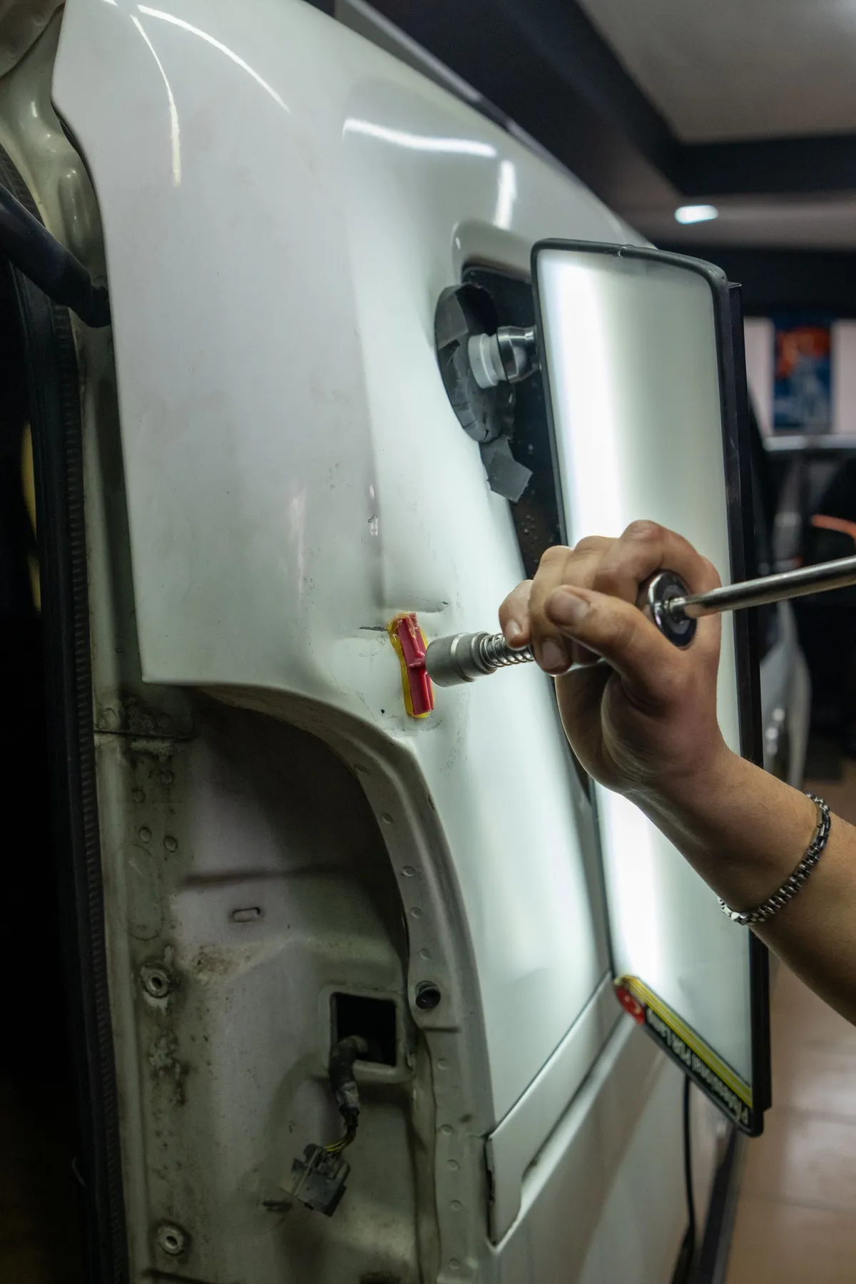 Dent removal work on a car door