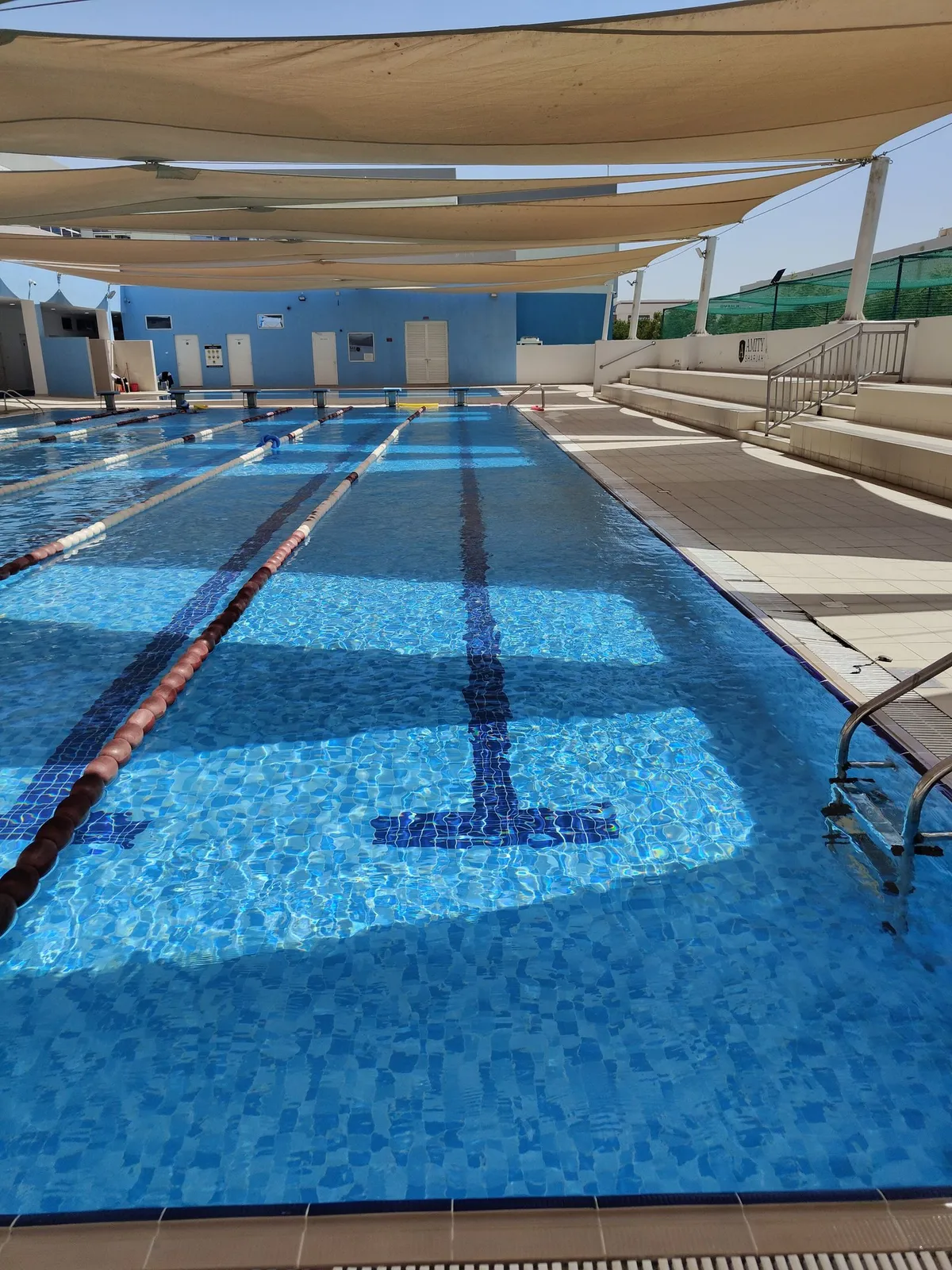 Long lap pool with lane ropes under shade sails