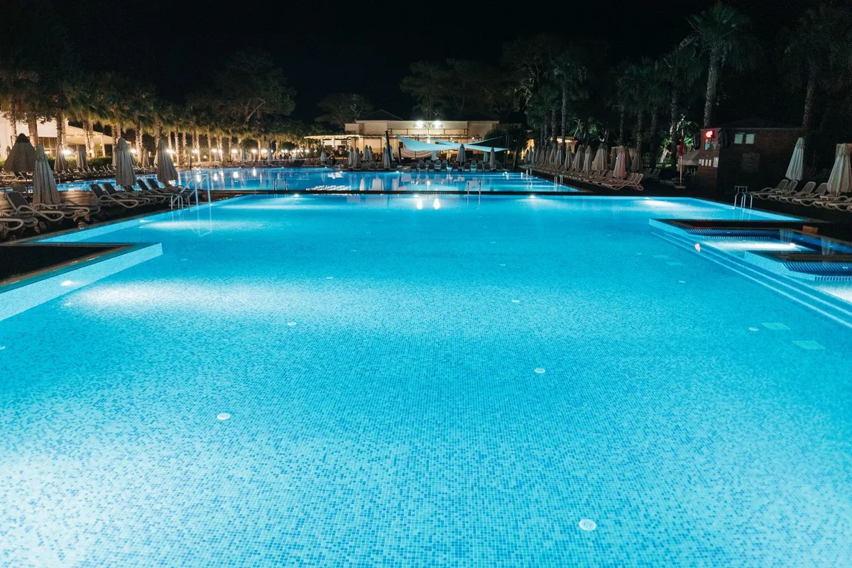 Pool glowing blue at night with underwater lighting