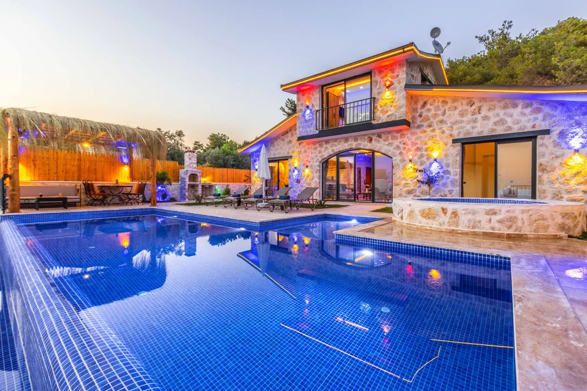 Pool with a raised round stone spa at dusk